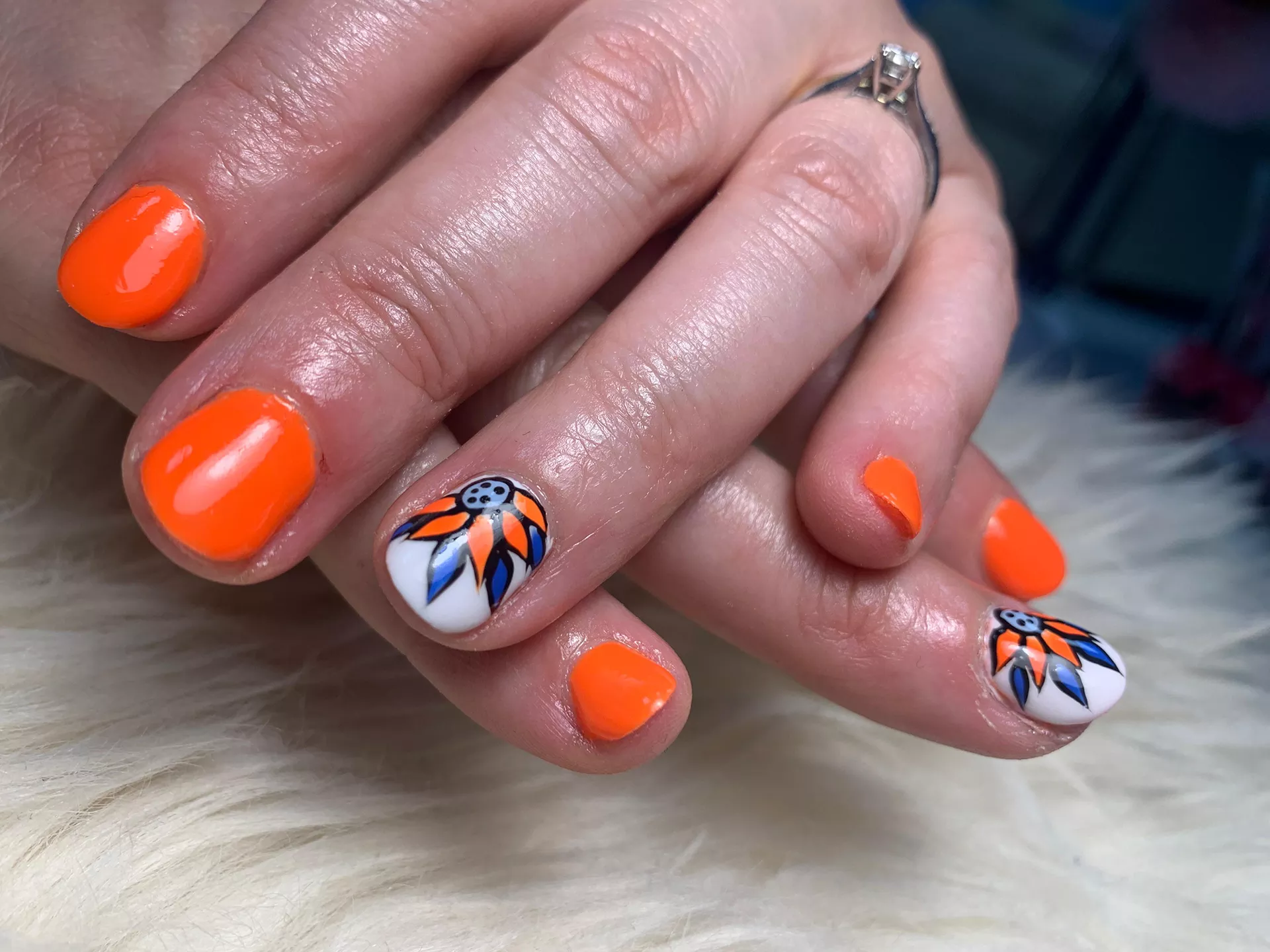 Trabajo en uñas color naranja y dibujo